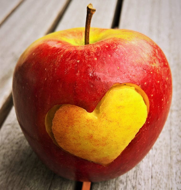 an apple with a heart cut into the skin