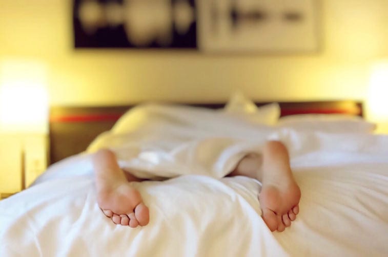 feet poking out of bed sheets