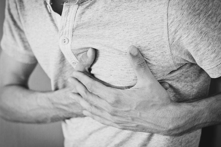 man with shingles pain clutches chest