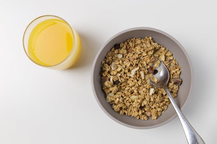 a bowl of grain cereal and a glass of orange juice
