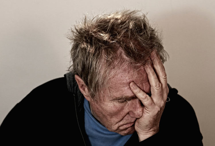 man holding his head in intense pain