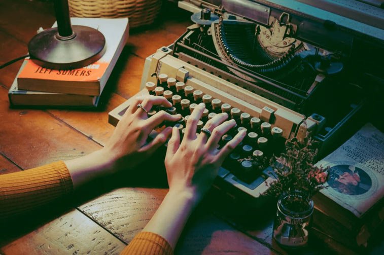 a woman's hands typing on a typewriter